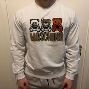 Vit sweatshirt med moschino och nalle tryck - Storlek XL men passar L/M