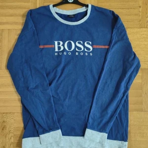 Hugo Boss - Blå långärmad från Hugo Boss till salu. Bra skick inga skador eller slitningar, tröjan är i storlek L. Nypris ligger på 1400 kr. Hör av er vid intresse eller funderingar.  PRIS KAN DISKUTERAS!