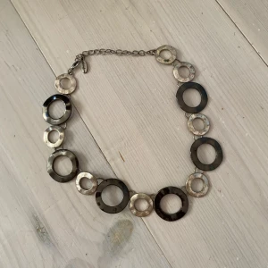 Silverfärgat halsband med stora cirklar - Säljer ett snyggt halsband i silverfärg med stora och små cirkelformade länkar. Kedjan är justerbar och halsbandet ger ett coolt och modernt intryck. Perfekt accessoar för att lyfta din outfit.