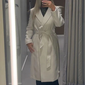 Beige/krämvit kappa - Beige/krämvit mellanlång kappa, använd några gånger, har knappar man kan stänga med, storlek s, 