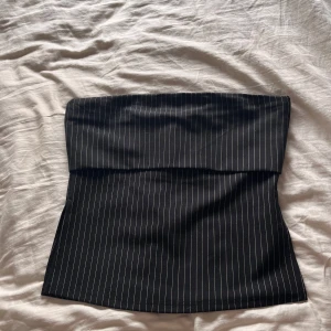 Tubtopp - Snygg svart tubtopp som passar perfekt till fest. Passar storlek S-L. Den är aldrig använd. Prislappen är kvar.