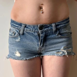 Lågmidjade jeansshorts minishorts med hål  - Storlek 32 enligt lapp men något stora i storleken (passar mig som oftast bär 34) midjemått:36. Köp sker via köp nu, jag postar inom 24h. Kvar tills markerad såld.