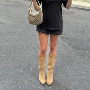 Svart jeanskjol - Säljer en snygg svart jeanskjol med rå kant. Perfekt för en avslappnad och trendig look. Kjolen har en klassisk design med en kort längd som passar bra till både vardag och fest.