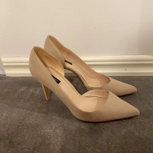 Beige pumps med spetsig tå från Mango - Stilrena pumps från Mango i beige mocka med spetsig tå och hög klack. Snygg minimalistisk design som ger en elegant look. Perfekta för dig som gillar klassiska och trendiga skor med en modern touch. 