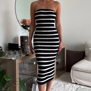 Klänning H&M slutsåld - Säljer en tight svartvit randig tubklänning i ribbat material. Klänningen är midilång och sitter figurnära. endast använd 1 gång.