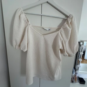 Cremevit blus med puffärmar - Säljer en cremevit v ringad blus med puffärmar. Super snyggt till både jeans och kjol och passar perfekt nu i sommar🌸
