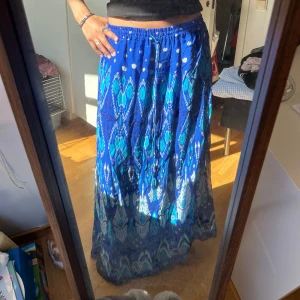Blå mönstrad långkjol från Zara - Snygg blå långkjol från Zara med coolt mönster i olika blå nyanser. Kjolen är lång på mig som är ungefär 174