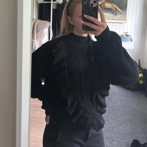 Stickad tröja med volanger - Stickad svart tröja med volanger i storlek S, osäker på märke då det inte står på lappen. Tar gärna emot prisförslag💕