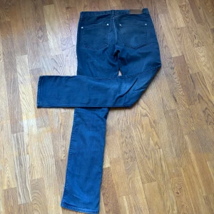Mörkblå jeansbyxor - Snygga mörkblå jeansbyxor med klassisk femficksdesign och slimfit. Byxorna är perfekta för en snubbe med skön stil. De är tillverkade i ett slitstarkt denimtyg och är lite gråare än vad som syns på bilden