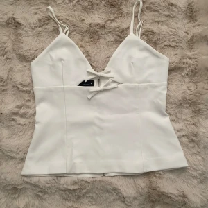 Vit korsettopp med dragkedja - Säljer denna super fina toppen från zara som jag aldrig använt! Är i storlek M men passar mig som har storlek S perfekt. Såld för 329kr men säljer för 270!💘 Skriv privat om du har några frågor!