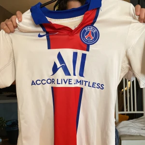 Vit och röd PSG fotbollströja - Säljer en snygg PSG fotbollströja från Nike, med neymar Jr på ryggen! Har använt fåtal gånger. Bara att höra av er om de är något!