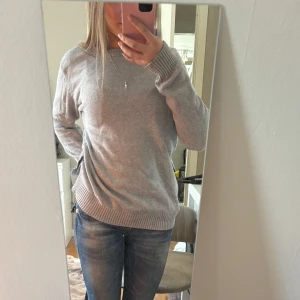 Grå stickad tröja - Säljer en stilren grå stickad tröja med rund hals och långa ärmar. Bara lite skrynklig men går att stryka