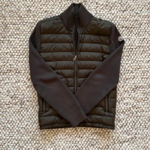 Moncler Cardigan  - Säljer nu min moncler cardigan i den här eftertraktade färgen - Olivgrön. Jackan är i storlek S och har inga hål eller liknande! Självklart äkta och äkthetsbevis följer med! Vid frågor är det endast att höra av sig! 📩 pris går att diskutera vid smidig affär