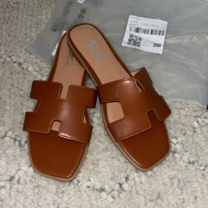 Oran Sandaler Shein - Snygga bruna sandaler från Shein med öppen tå och breda remmar i syntetmaterial. Perfekta för sommardagar med sin stilrena design och bekväma passform. Oran liknande. HELT NYA, aldrig använda och säljer pga stora för mig. Fotlängd 27 CM och US 11.  