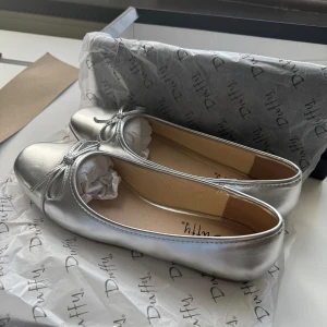 Silvriga ballerinaskor från Duffy - Snygga silvriga ballerinaskor från Duffy. Aldrig använda. Säljer då de var för små. Kan mötas upp i Lund!