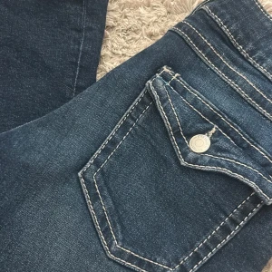 Mörkblå jeans från Ginatricot - Säljer mina blåa low waist bootcut jeans från Gina på grund av att de är för små. De är i ett mycket bra skick och knappt använda. Det finns resår i de och de är i storlek 158, men skulle säga att de passar dig som är runt 160cm💕skriv till mig för fler bilder!