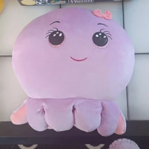 Octavia Squishmellow från Ty - Fina Octavia squishmellow från Ty med stora glittriga ögon och en liten rosa rosett på huvudet. Kudden är mjuk och perfekt som dekoration eller kramkompis. Den har flera ben och ett glatt ansikte som gör den extra charmig. Hon är väldigt stor!