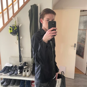 Svart overshirt  - Säljer dennna svarta overshirt från beyond retro då den tyvärr är för kort för mig som är 183. Annars schysst skick på den och riktig go till alla fits.