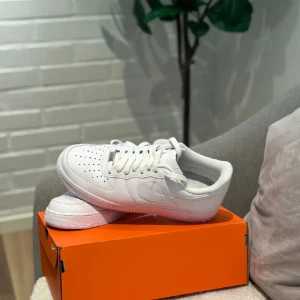 Vita Nike Air Force sneakers - Säljer ett par klassiska vita Nike Air Force sneakers. De har en stilren design med snörning och rund tå. Perfekta för en casual look och passar till det mesta. Kommer i originalkartong.