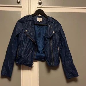 Blå skinnjacka  - Blå skinnjacka från Pepe Jeans London i storlek XS/12💙 Jackan har dragkedjor och flätade detaljer med långa ärmar och tryckknappar vid kragen, perfekt nu till våren! 🌼🌷🌺