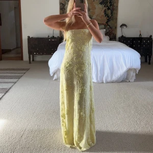 Gul axelbandslös långklänning - Elegant smör-gul axelbandslös långklänning med broderat blommigt mönster. Perfekt som balklänning eller till midsommar/bröllopsgäst. Klänningen har en smickrande passform och är tillverkad i ett lätt och luftigt material. Slutsåld på hemsidan!💛💛