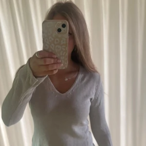 Ljusgrå stickad v-ringad tröja H&M - Superskön ljusgrå stickad tröja från H&M L.O.G.G. med v-ringning och lång ärm. Perfekt för lager-på-lager och chill stil. Mjuk bomullskvalitet och enkel design som funkar till jeans eller kjol. Säljes i storlek S.