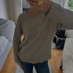 Beige stickad tröja från Vero Moda - Mysig beige stickad tröja från Vero Moda med rund halsringning och ribbade muddar. Långärmad och i en klassisk, enkel modell som funkar till allt!