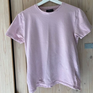 Clifton t-shirt - Ljusrosa använd t-shirt i bra skick. Längd 57 cm, bröstbredd 43 cm.