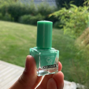 Mintgrönt nagellack Golden Rose - Fräsch mintgrön nagellack från Golden Rose Ice Color-serien. Kommer i en snygg fyrkantig glasflaska med matchande grön kork. Perfekt för dig som vill ha en poppig och trendig färg på naglarna. Lätt att applicera och ger en jämn finish.