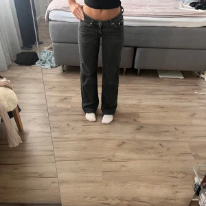 Svarta raka jeans med låg midja - Säljer ett par svarta jeans med låg midja och raka ben. Jeansen har klassisk femficksdesign, silverfärgade nitar och synliga sömmar. Köpa på WEEKDAY i passformen Arrow 🌸