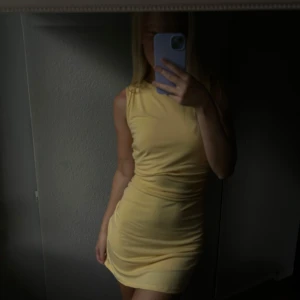 Gul kortklänning - Säljer en ljusgul, tight och ärmlös kortklänning med rund hals. Från NAKD, bra skick