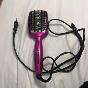 Babyliss värmeborste i metallicrosa - Säljer en elektrisk värmeborste från Babyliss i metallicrosa. Borsten har bred, platt form med svarta piggar och silverdetaljer. Perfekt för att styla och räta ut håret snabbt. Utrustad med lång sladd och enkel on/off-knapp på handtaget.