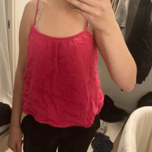 Rosa linnetopp  - Säljer en söt rosa linnetopp med tunna axelband. Toppen har en lös passform och är perfekt för varma dagar. Materialet känns lätt och luftigt, och den har en enkel men trendig look.