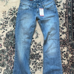 Unika lågmidjade bootcut jeans - Ljusblå lågmidjade bootcut jeans i strl 28 