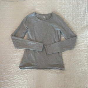 Grå långärmad tröja från Cubus - Snygg grå långärmad tröja från Cubus i storlek XS. Enkel och stilren design med rund halsringning och mjukt material som känns skönt mot huden. Perfekt att ha som basplagg och lätt att matcha med andra kläder. Passar dig som gillar en clean och chill look.
