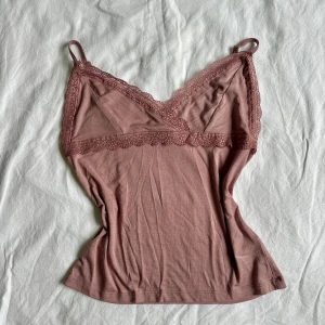 Topp  - Supersöt ljusrosa linnetopp från Cubus med tunna axelband. Toppen har fina spetsdetaljer längs urringningen och under bysten. Mjuk och stretchig bomullsblandning som sitter skönt mot kroppen. Vid köp av flera varor får du rabatt!