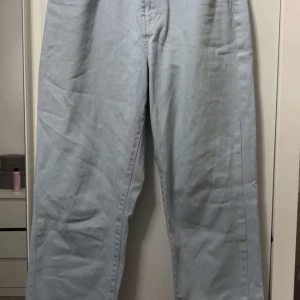 Ljusblå jeansbyxor från New Yorker  - Säljer ett par ljusblå jeansbyxor från Amisu med raka ben och klassisk femficksdesign. Byxorna har normal passform och är tillverkade i mjukt bomullstyg. Perfekta för en chill och stilren look. Dock har de en liten fläck från en tuschpenna, som är svår att få bort.