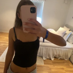 Svart croppat linne - Svart linne från Gina i strl S, extra tyg runt bröstet. Perfekt basic linne.