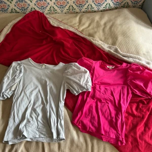 Två puffärmade toppar XS H&M - Säljer två snygga toppar från H&M i storlek XS. En är ljusgrå och den andra är knallrosa, båda med trendiga puffärmar och rund halsringning. Perfekta för att ge outfiten lite extra attityd. Mjukt bomullsmaterial som är skönt mot huden. 20kr för båda