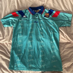 FC Barcelona Kappa fotbollströja - Säljer en retro FC Barcelona fotbollströja från Kappa i turkos polyester med korta ärmar. 