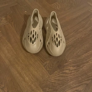 Adidas Yeezy Foam Runner “Sand”  -  Säljer ett par Adidas Yeezy Foam Runner i färgen Sand. Lättviktiga, bekväma och perfekta både hemma, på stan eller till stranden. Gjorda av EVA-skum med hållbar design och unik, futuristisk look. 	•	Storlek: 37 	•	Skick: Mycket bra, sparsamt använda (se bilder) 	•	Pris: 600 kr   Finns på Södermalm vid Mariatorget Kan skickas mot frakt eller mötas upp. Först till kvarn.