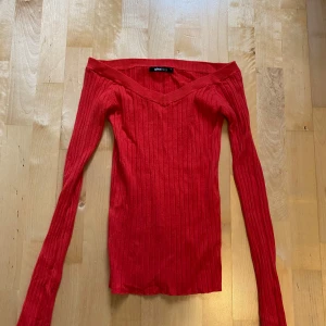 Röd ribbad offshoulder tröja Gina Tricot - Säljer en snygg röd ribbad tröja från Gina Tricot i storlek XS. Modellen är offshoulder med lång ärm och tight passform, perfekt för dig som gillar att sticka ut. Materialet är mjukt och stretchigt, vilket gör den skön att bära. Passar dig som vill ha en trendig look.