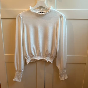 Vit blus med volang Gina Tricot - Supersöt vit blus från Gina Tricot i storlek S💘Blusen har volangdetaljer vid halsen & smock vid ärmslut💓💓mycket bra skick💞
