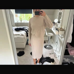 Beige stickad långkjol och tröja  - Säljer en beige stickat set,  mjukt och skön känsla. Kjolen har en rak passform och slutar strax under knäna. Perfekt för dig som gillar en enkel och stilren look med neutrala färger. Du kan köpa separat med! 