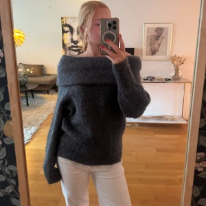 Mörkgrå offshoulder stickad tröja - Säljer en supermysig mörkgrå stickad tröja med bred offshoulder-krage. Helt ny och perfekt hösttröja