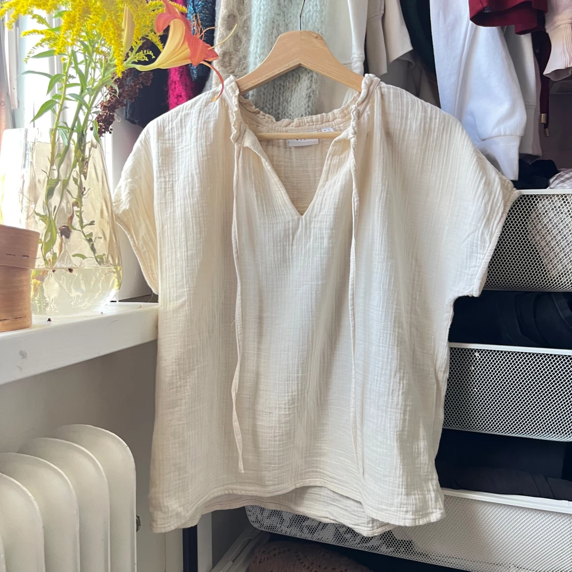 Ljusbeige blus med knyt i halsen