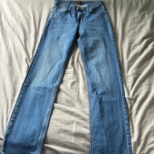 Nice Lee Jeans 29/32 - Klassiska blå jeans från Lee med rak passform och normal midja. Jeansen har fem fickor, Lee-lapp bak och är tillverkade i slitstarkt denim. Perfekta för dig som gillar en tidlös och avslappnad look.