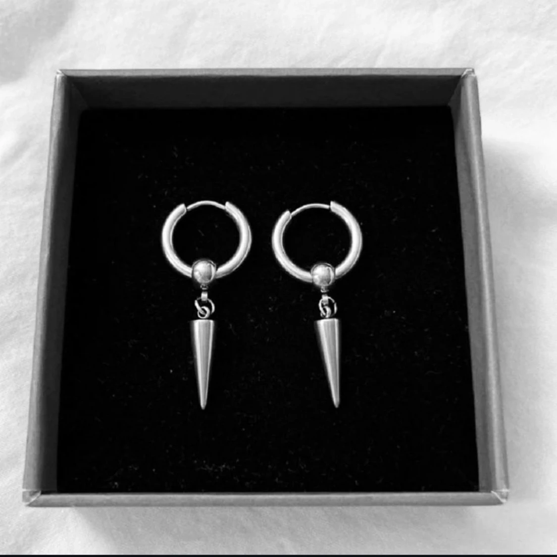 Silvriga örhängen med konformad detalj