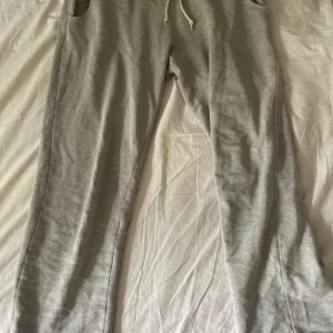 Grå mjukisbyxor från The Essentials - Snygga grå mjukisbyxor från The Essentials by Care Marne. Tillverkade i mjuk ekologisk bomull och har dragsko i midjan för skön passform. Perfekta för chill dagar eller när du vill vara bekväm men ändå se fräsch ut.