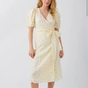 Prickig omlottklänning från Gina Tricot - Superfin ljus omlottklänning med svarta prickar från Gina Tricot. Klänningen har puffiga korta ärmar, v-ringning och knytband i midjan. Längden är mitt på vaden och tyget är lätt och luftigt, perfekt för varma dagar. Endast använd 1 gång!